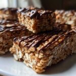 Close-up of homemade protein bars made with oats and drizzled with melted chocolate.