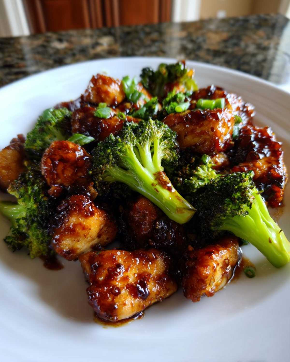 Close-up of tender, glazed chicken and bright green broccoli florets, a perfect chicken and broccoli dinner.