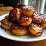 Close-up of perfectly caramelized and golden roast potatoes sprinkled with flaky sea salt.