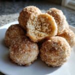 A stack of soft cinnamon sugar snowball cookies, one broken open to show the crumb texture.