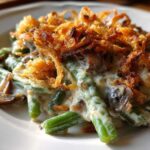 Close-up of a serving of classic green bean casserole topped with creamy sauce and crispy fried onions.
