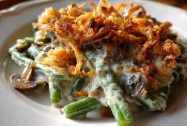 Close-up of a serving of classic green bean casserole topped with creamy sauce and crispy fried onions.