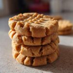 A close-up stack of four Easy Peanut Butter Cookies showing the classic crisscross fork marks.