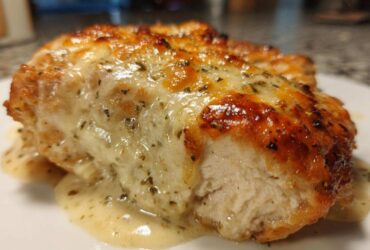 A close-up cross-section of a perfectly cooked Garlic parmesan chicken bake with melted cheese topping.