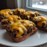 Five servings of the hanky panky recipe served open-faced on toasted bread slices topped with melted cheddar cheese.