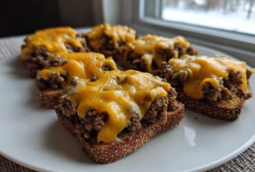 Five servings of the hanky panky recipe served open-faced on toasted bread slices topped with melted cheddar cheese.