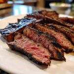 Close-up of medium-rare sliced steak, showing char marks from grilling, prepared with carne asada marinade.