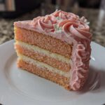 A tall slice of layered rose cake featuring pink and white sponge layers and pink rosette frosting.