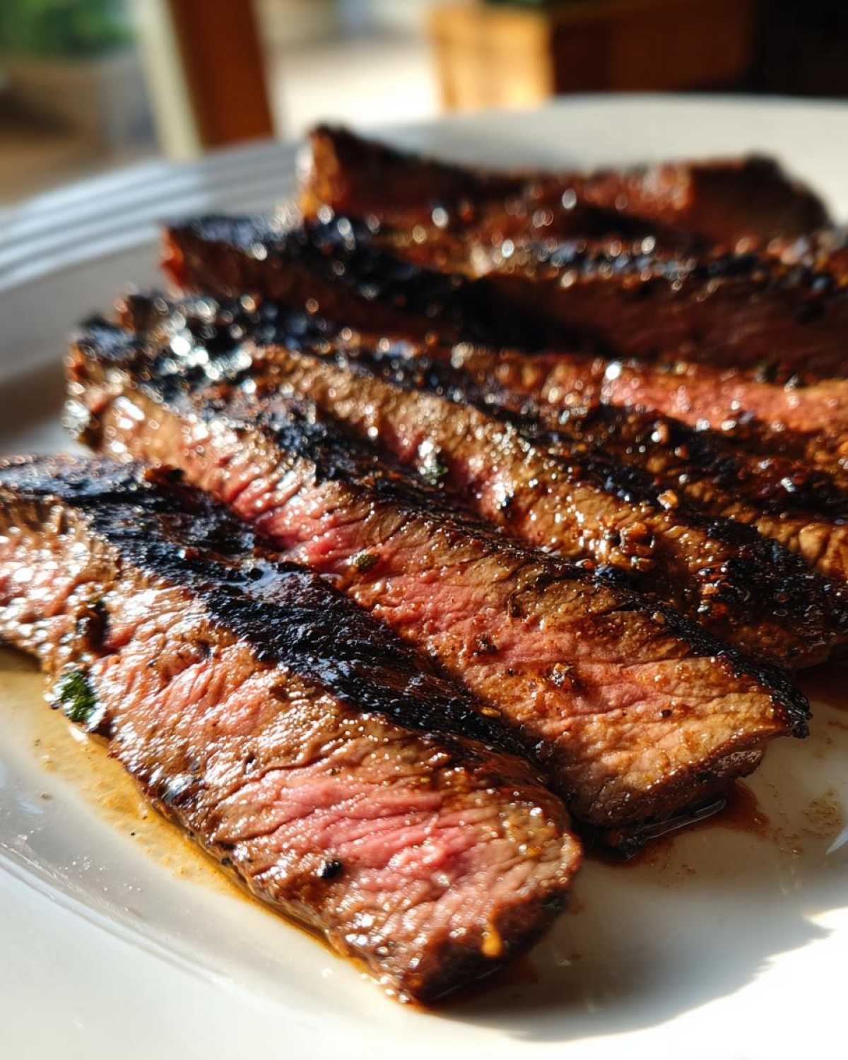 Close-up of medium-rare sliced steak showing char marks, glistening from the carne asada marinade.