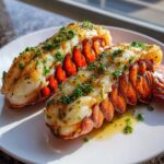 Two perfectly cooked Air Fryer Garlic Butter Lobster Tails glistening with butter and topped with fresh parsley.