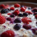 A close-up, macro view of Easy Berry Chia Overnight Oats topped with fresh raspberries, blueberries, and blackberries.