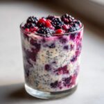 Close-up of Easy Berry Chia Overnight Oats layered with yogurt, oats, chia seeds, and topped with fresh blackberries and raspberries.