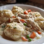 Close-up of creamy Instant Pot Chicken and Dumplings with fluffy dumplings and shredded chicken.