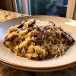 A close-up of Instant Pot Creamy Mushroom Risotto topped with sautéed mushrooms and grated Parmesan cheese.