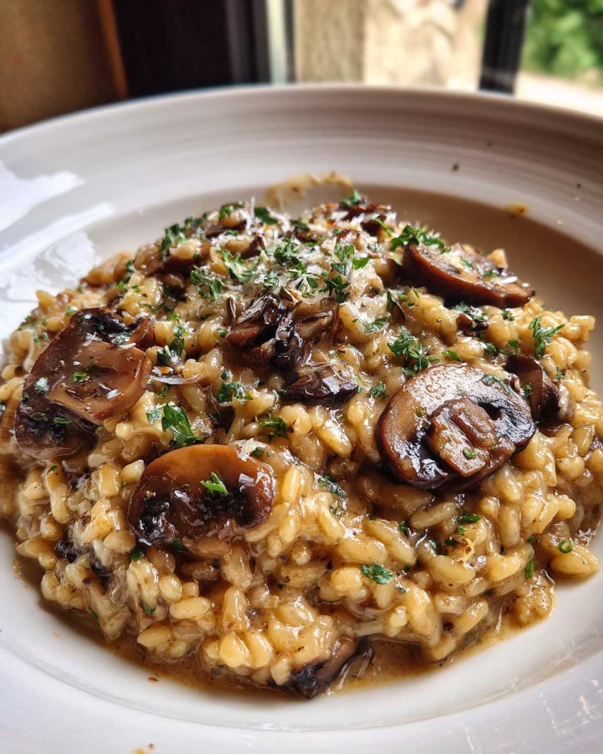 Close-up of rich Instant Pot Creamy Mushroom Risotto topped with sautéed mushrooms and parsley.