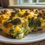 Close-up of a serving of Keto Cheesy Broccoli Casserole with browned, melted cheddar cheese on top.