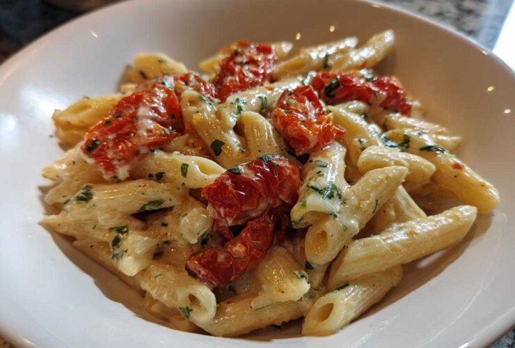 Close-up of One-Pot Creamy Goat Cheese Pasta with penne, creamy sauce, and roasted red tomatoes.