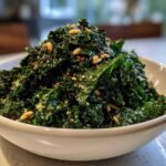 A white bowl filled with massaged kale, pine nuts, and spices, representing the Copycat Kale Crunch Salad.
