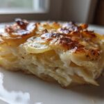 A close-up of a single serving of the Easy 30-Minute Cheesy Side Dish, showing layered potatoes baked in a creamy sauce with a browned top.