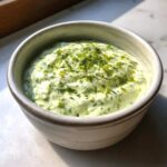 Close-up of Easy 5-Minute Salsa Verde Yogurt Dip, light green and creamy, topped with zest.