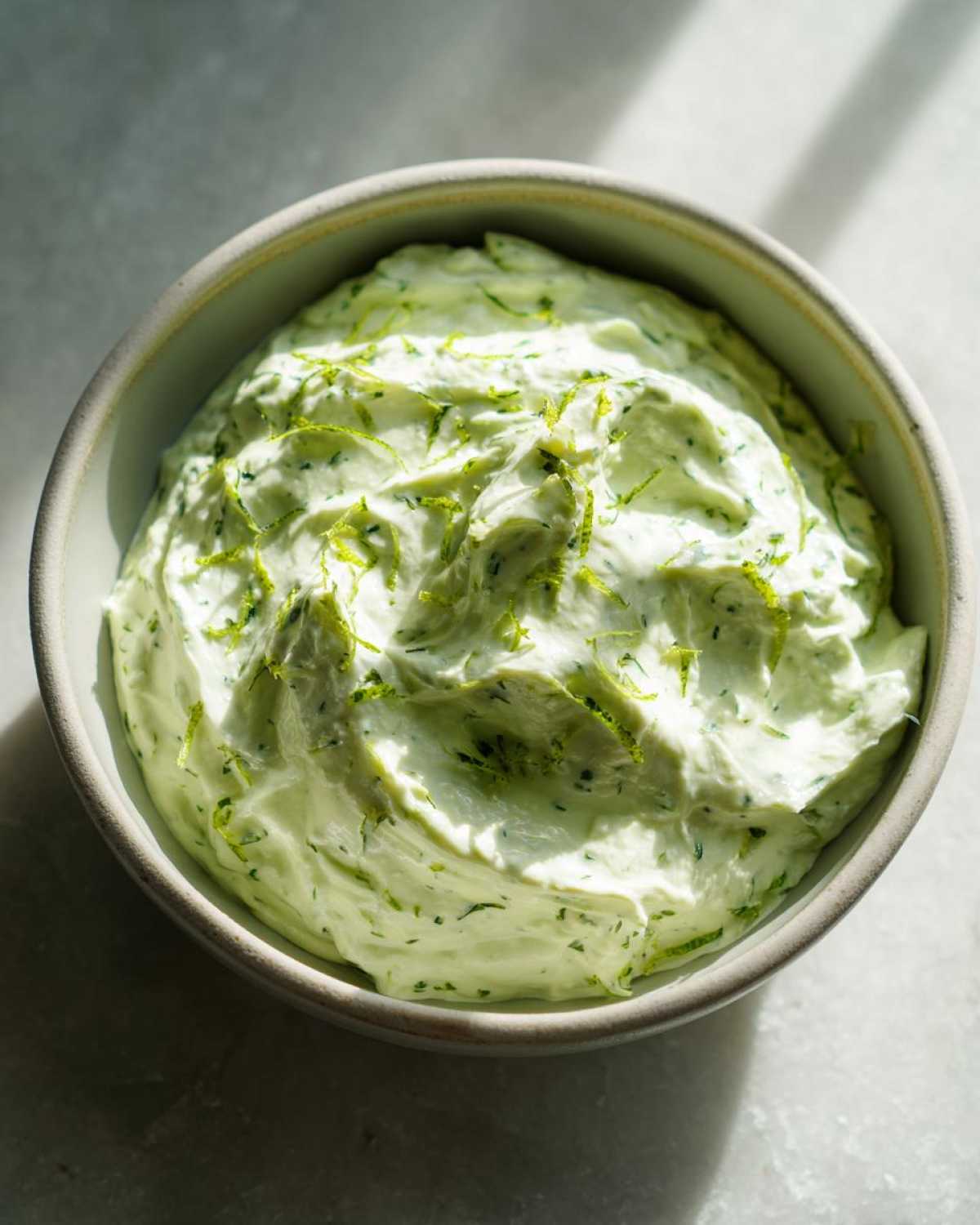 A creamy bowl of Easy 5-Minute Salsa Verde Yogurt Dip, topped with bright green lime zest.
