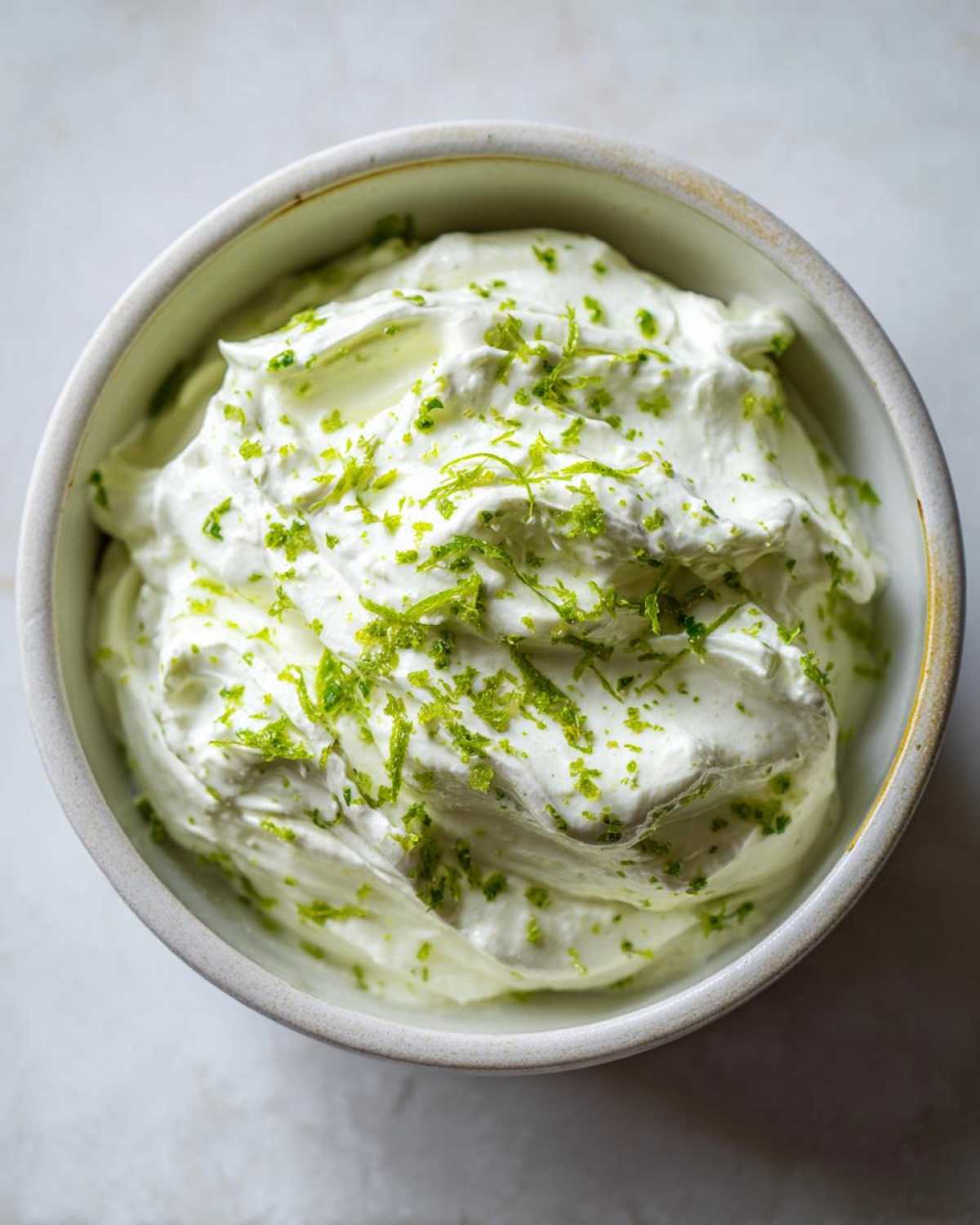 Close-up of creamy white yogurt dip topped with bright green lime zest, representing the Easy 5-Minute Salsa Verde Yogurt Dip.