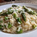 Close-up of Easy Creamy Asparagus Risotto topped with fresh asparagus spears and grated Parmesan.