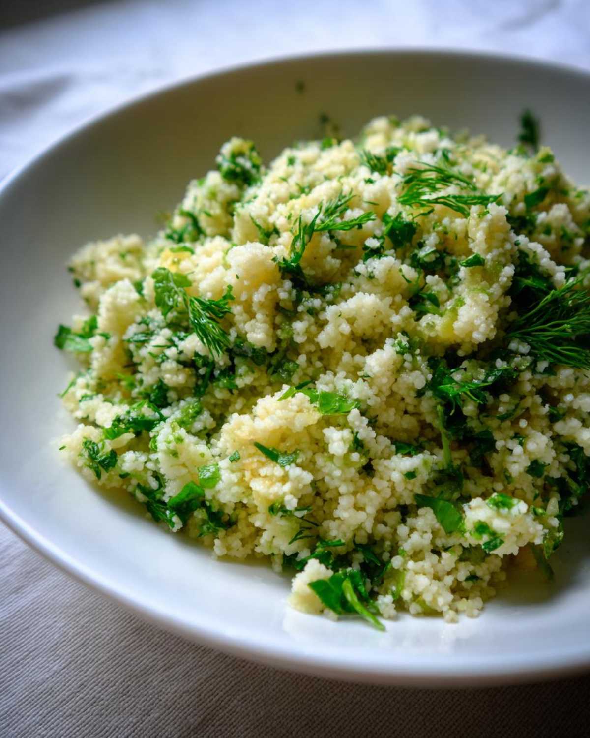 Close-up of fluffy couscous mixed with bright green herbs, showcasing the Easy One-Pot Creamy Lemon Herb Couscous.