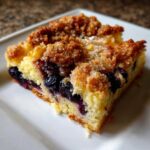 Close-up of a square slice of Easy Sheet Pan Blueberry Streusel Pancake with a thick, sugary crumb topping.