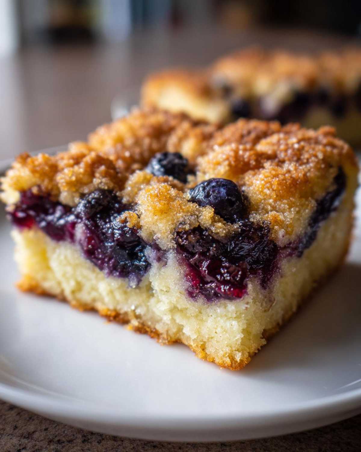 Close-up of a square slice of Easy Sheet Pan Blueberry Streusel Pancake with juicy blueberries and a sugary streusel topping.