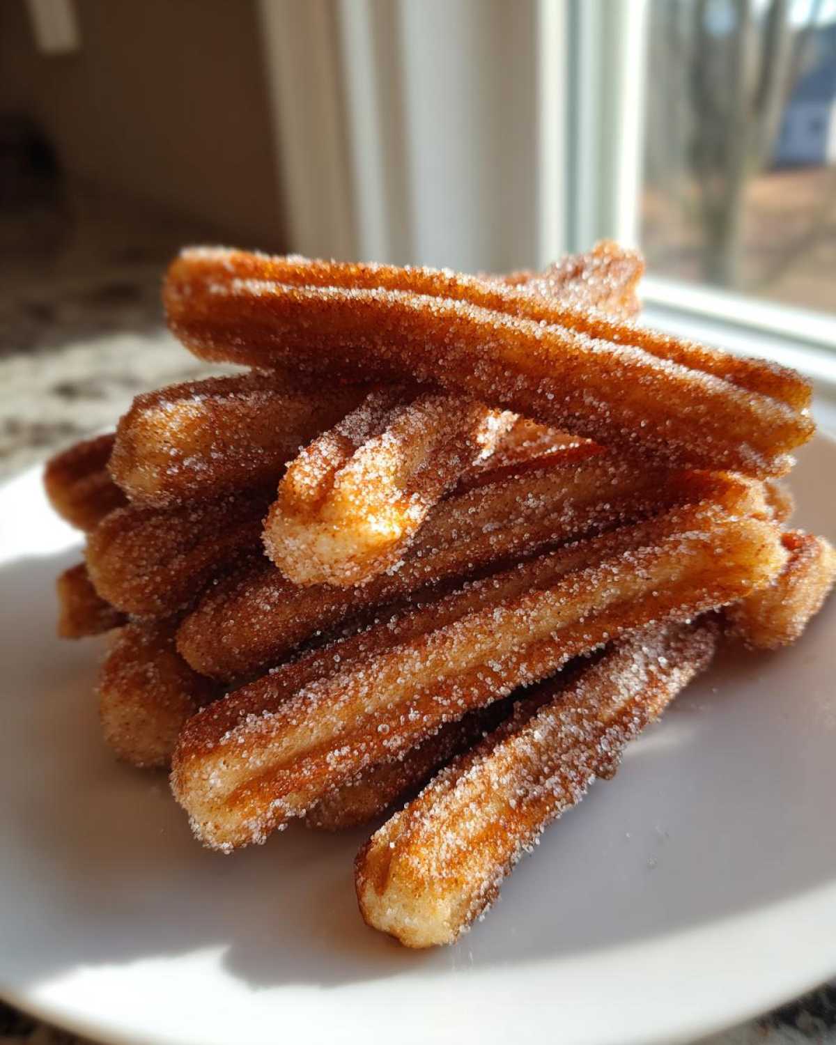 A stack of crispy Gluten-Free Cinnamon Sugar Waffle Sticks heavily coated in sparkling sugar.