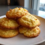 A stack of five golden brown, soft cake mix cookies piled on a white plate.