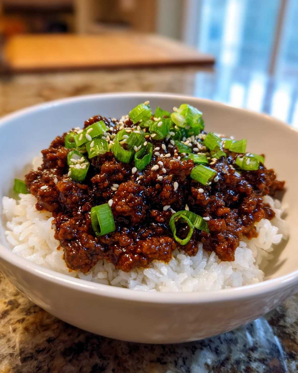 Close-up of Instant Pot Korean Beef and Rice Bowls topped with green onions and sesame seeds.