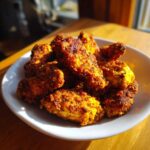 A pile of golden brown, crispy Keto Crispy Parmesan Chicken Wings served in a white bowl.