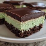 A close-up of a square No-Bake Chocolate Mint Icebox Bars slice showing chocolate crust, mint filling, and chocolate ganache topping.