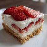 Close-up of a square slice of No Bake Spring Strawberry Dessert showing graham cracker crust, creamy filling, and fresh strawberry topping.