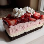 A perfect slice of No-Bake Strawberry Chocolate Cheesecake Slice showing three distinct layers and whipped cream.