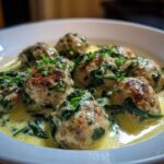 Close-up of One-Pan Creamy Lemon Garlic Turkey Meatballs served in a white bowl with creamy sauce and spinach.