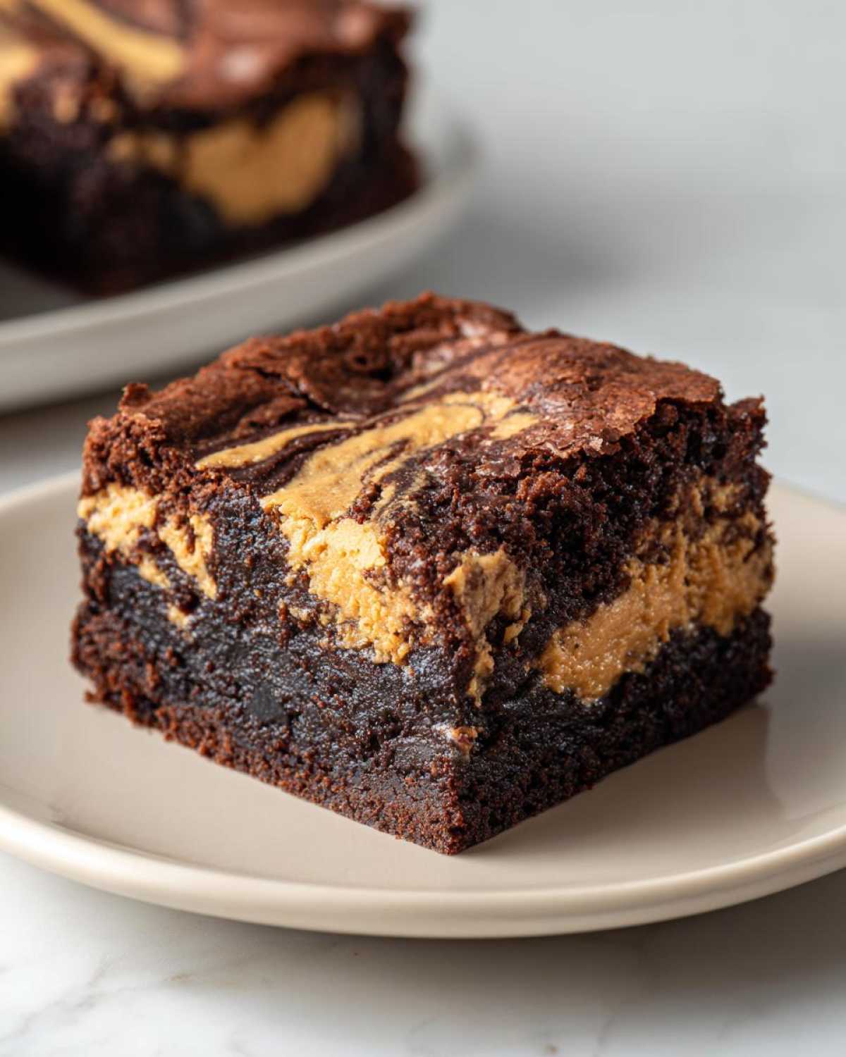 A rich, fudgy square of peanut butter swirl brownies served on a light plate.