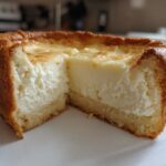 Cross-section of a baked cheesecake showing a thick, creamy filling and golden crust, illustrating perfect ies consistency.