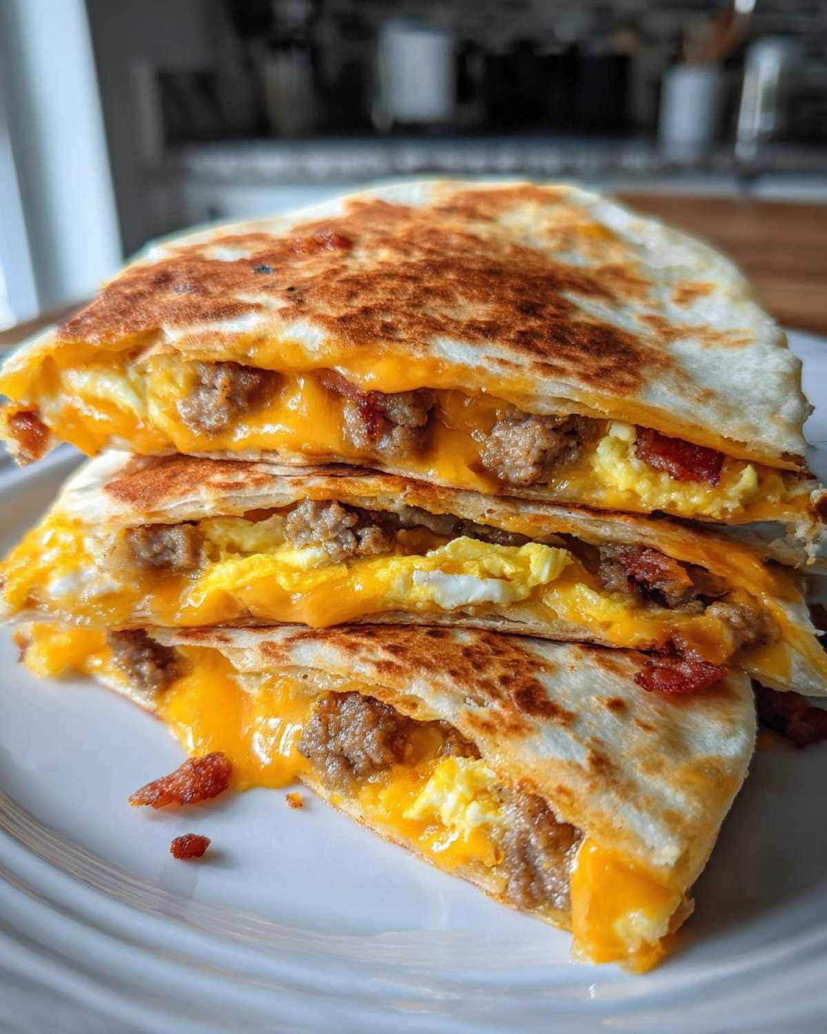 Close-up of stacked, golden-brown Sheet Pan Breakfast Quesadillas filled with melted cheddar cheese, scrambled eggs, and sausage.
