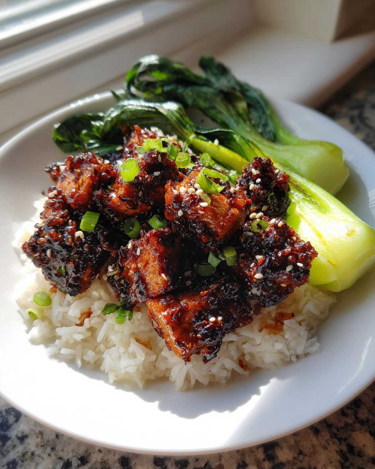 Close-up of Vegan Crispy Sesame Tempeh Bowl served over white rice with steamed bok choy.