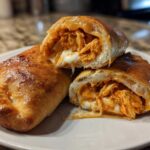 Close-up of Buffalo Chicken Pockets cut open showing shredded chicken filling and melted cheese.
