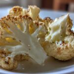 Close-up of perfectly roasted Garlic Butter Roasted Cauliflower florets showing caramelized edges and a glossy coating.