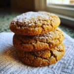 Three soft Maple Brown Sugar Cookies stacked on a white napkin, dusted with coarse sugar.