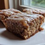 Close-up of three Moist Banana Bars with Browned Butter Vanilla Glaze squares on a white plate.