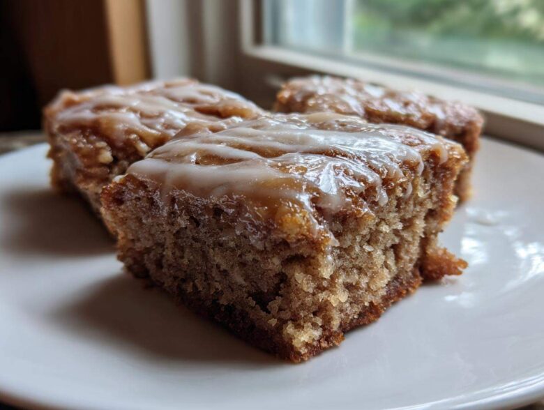 Close-up of three Moist Banana Bars with Browned Butter Vanilla Glaze squares on a white plate.