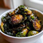 Close-up of perfectly caramelized and glazed Yard House Brussels Sprouts served in a small white bowl.