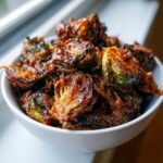 Close-up of crispy, caramelized Yard House Brussels Sprouts piled high in a white bowl.